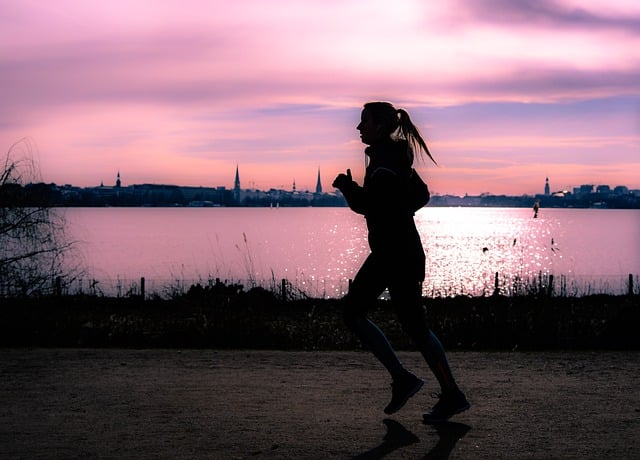 Frau geht im Sonnenaufgang joggen.